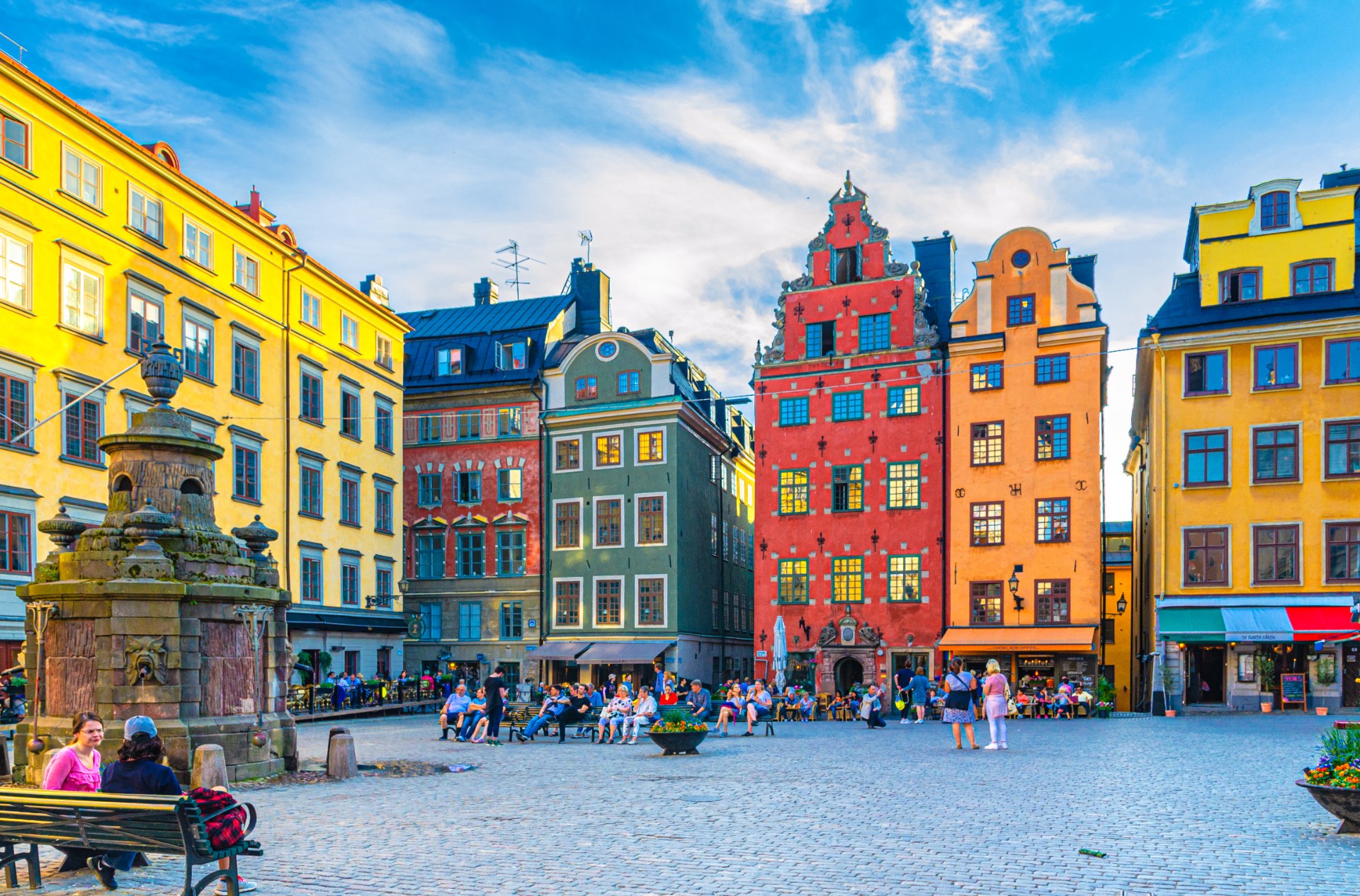Turisté a kolemjdoucí na náměstí Stortorget ve Stockholmu mezi barevnými měšťanskými domy